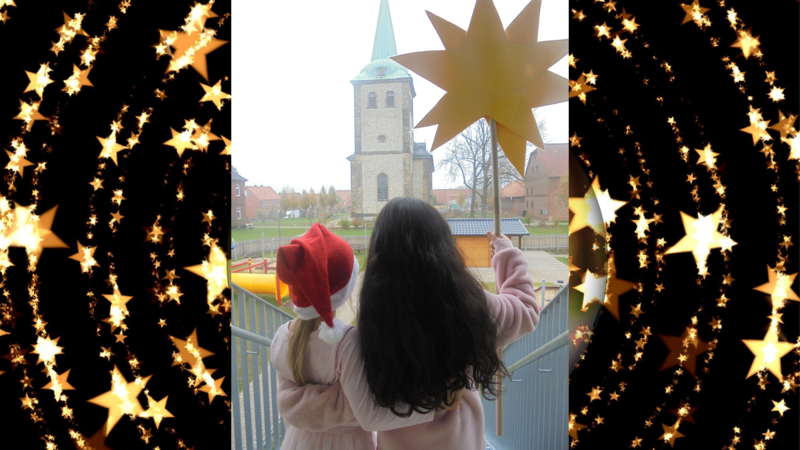 Mädchen in rosa Kleidung mit Stern in der Hand blicken zur Kirche